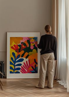 a woman standing in front of a colorful painting