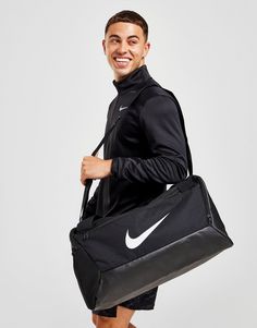 From big gym sessions to weekends away, keep your gear secure with this Brasilia Large Duffle Bag from Nike. In a black colourway, this spacious bag is made from durable poly fabric, with a coated bottom that shields and protects your essentials. It features two handle straps and a detachable shoulder strap for versatile carry, while multiple zippered compartments offer room to store your dry and wet clothes separately. With outer pockets for your easy-access items, this bag is finished up with signature Swoosh branding. Spot clean. (L: 71 x W: 35.5 x H: 35.5cm) Nike Gym Bag, Nike Duffle Bag, Nike Inspiration, Football Bag, Large Duffle Bag, Nike Bags, Wet Clothes, Nike Football, Duffle Bags