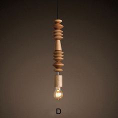 a wooden light bulb hanging from a string with the letter d on it's side