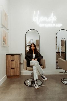 a woman sitting in a chair with her feet up on the hair table and looking at the camera