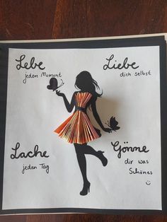 a piece of paper cut out of a woman's dress with words on it