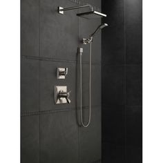 the shower head and handset are connected to the wall in this black tiled bathroom