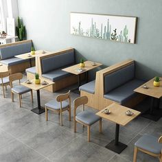 an empty restaurant with blue booths and wooden tables on the floor, along with gray chairs