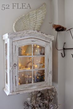 an old white cabinet with lights on it