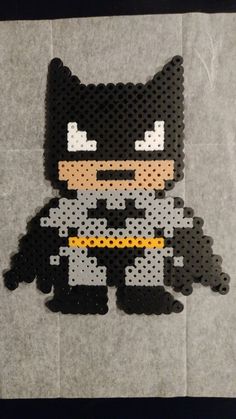 a batman made out of legos sitting on top of a piece of paper with the word