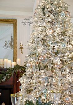 a white christmas tree with silver and gold ornaments