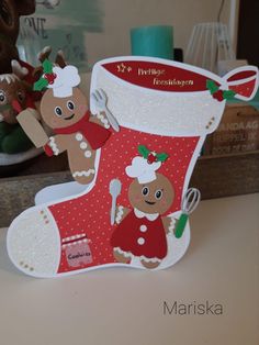 a christmas stocking with reindeers on it sitting on top of a table next to a stuffed animal