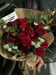 a person holding a bouquet of red roses