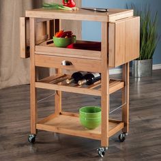 a small wooden cart with some wine bottles and bowls on the shelf next to it