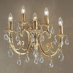 a gold chandelier with crystal drops hanging from it