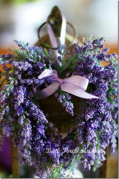 a bunch of purple flowers in a vase with a bow on it's neck