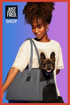 Image shows a young female holding a gray canvas dog carrier with a French Bulldog peeking its head out.  This vegan bag has zipped top and a peekaboo window.  Padded sides.  SHOP NOW AT JUST FRED.