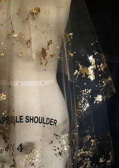 a mannequin is covered in gold flecks and black fabric with the words apple shoulder written on it