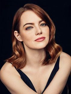 a woman with red hair and blue eyes is posing for a magazine cover photo in black dress