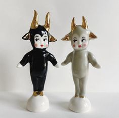 two ceramic figurines with horns on their heads