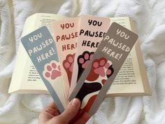 someone holding three bookmarks in their hand with the words you paused, pause, and here