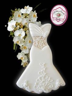 a wedding dress cookie next to a bouquet of flowers