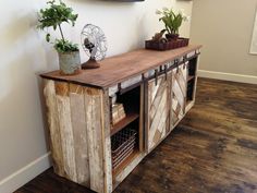 an image of a wooden cabinet with plants on top and the caption below it