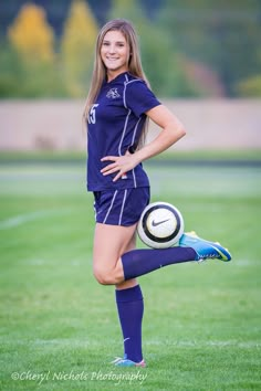 a young woman is posing with a soccer ball