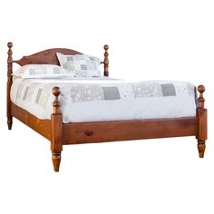 a bed with wooden posts and headboard, made in the style of an old - fashioned