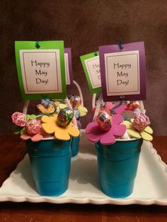 two buckets filled with flowers on top of a table