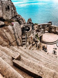 an outdoor theater with steps leading to the water