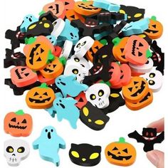 a pile of halloween buttons with faces and bats on them, all in different colors