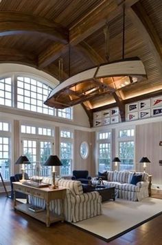 a living room filled with lots of furniture and large windows above it's ceiling