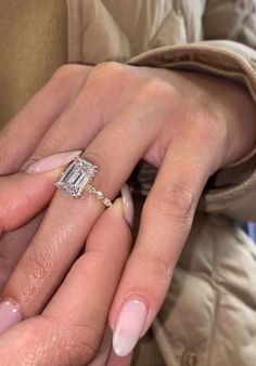 a woman's hand with a ring on it and a baguette in the other hand