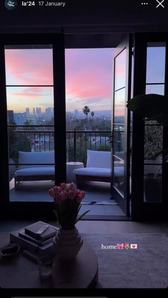 a living room filled with furniture and a view of the city at sunset or dawn