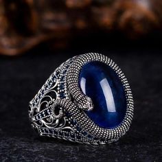 Step into the realm of mystique with our captivating Blue Tiger's Eye Ring adorned with intricate snake detailing. Crafted with care, this ring features a mesmerizing blue tiger's eye stone, exuding an aura of depth and allure. The snake motif, delicately engraved, adds an element of intrigue and symbolism to the design. Accented with shimmering zircon stones, this ring is a true statement piece that commands attention. Whether worn as a symbol of transformation or simply as a stunning accessory Snake Motif, Tigers Eye Ring, Blue Tiger Eye Stone, Grand Bazaar Istanbul, Thoughtful Gifts For Him, Snake Ring Silver, Jewelry Mens, Blue Tigers, Bold Jewelry