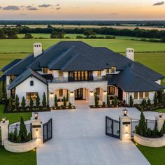 an aerial view of a large home with lots of windows and lighting in the front yard