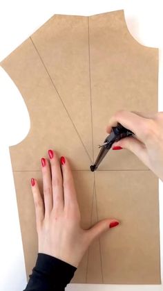 a woman cutting out a piece of cardboard with scissors