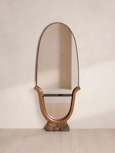 a mirror sitting on top of a wooden table next to a white wall with a shelf