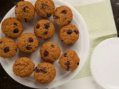 a white plate topped with muffins next to a cup of coffee and napkin