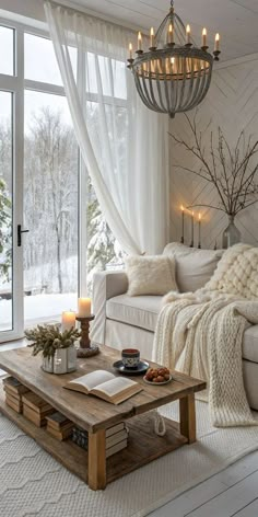 a living room filled with furniture and a chandelier hanging from the ceiling next to a window