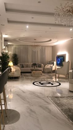 a living room filled with furniture and a chandelier hanging from the ceiling over a marble floor