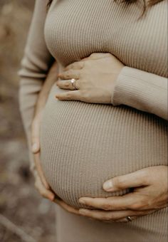 a pregnant woman's belly with her hands on her stomach