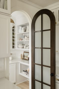 an open door leading into a white kitchen