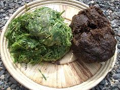 a plate that has some food in it on a table next to gravel and rocks