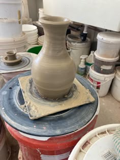 a large vase sitting on top of a piece of pottery