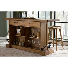 a kitchen island with wine glasses on it in front of a window and two stools