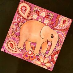 an elephant painted on top of a pink and purple background with paisley designs around it