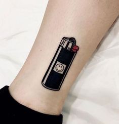 a small black lighter tattoo on the ankle