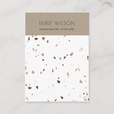 a white and brown business card with an abstract design on the front, featuring confetti