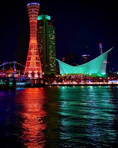 the lights on the building are reflecting in the water near the city's waterfront