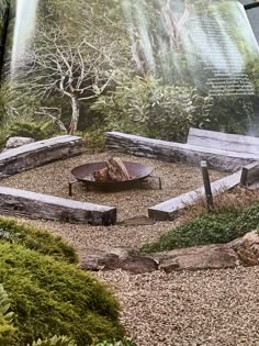 an open book showing a garden with rocks and trees in the background, including a fire pit