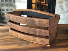 a wooden box sitting on top of a table next to a fire place with a fireplace in the background