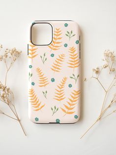 a phone case with an orange and blue floral pattern on it next to some flowers