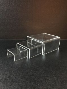 three clear acrylic boxes sitting on top of a black counter